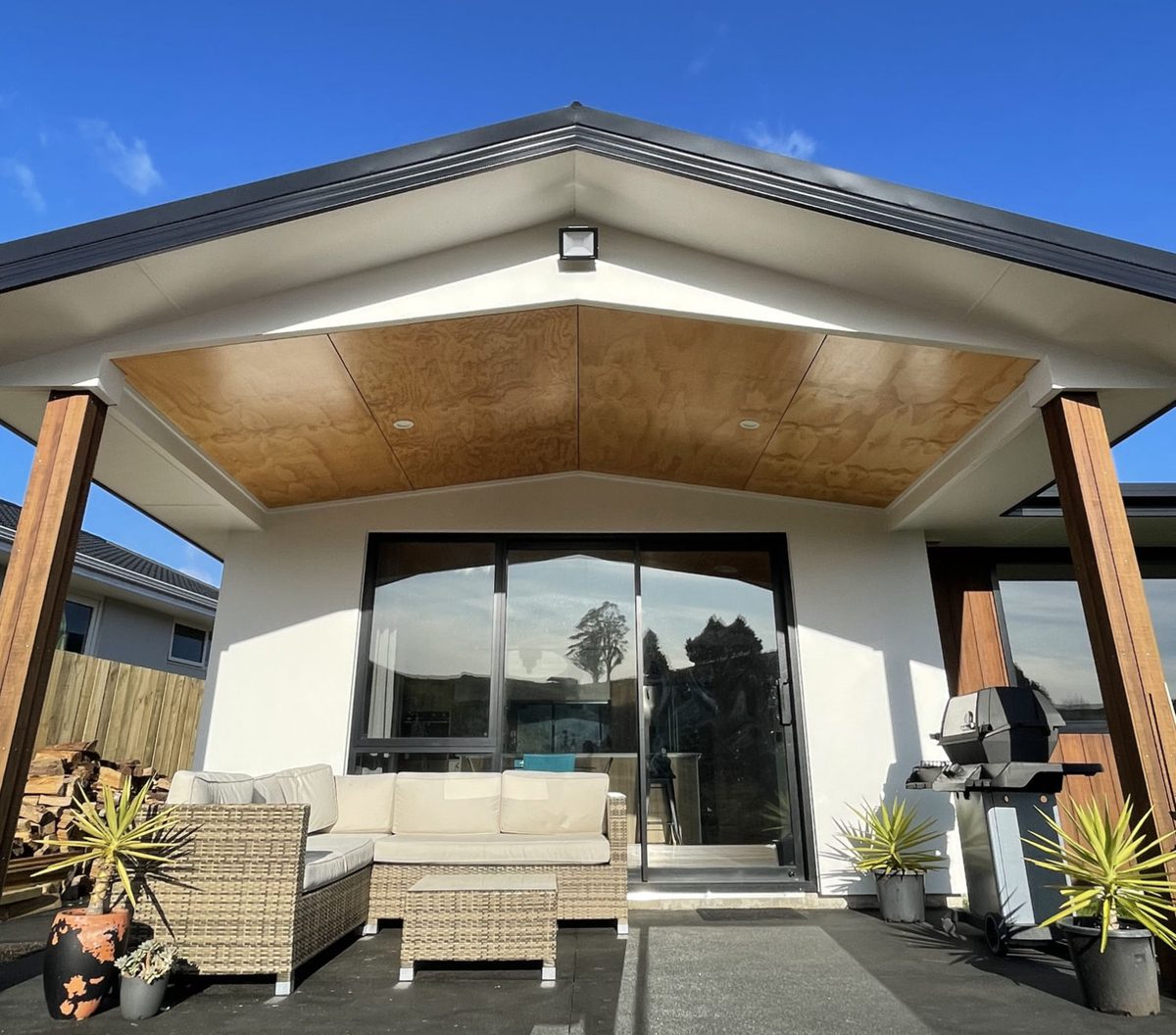 Covered outdoor living area with plywood ceiling and cedar posts