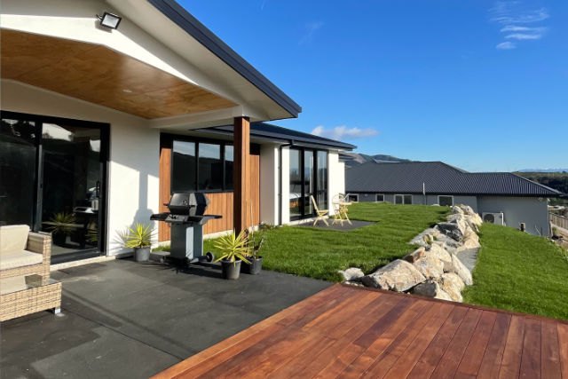 New deck, lawn and covered patio beside a Nelson home